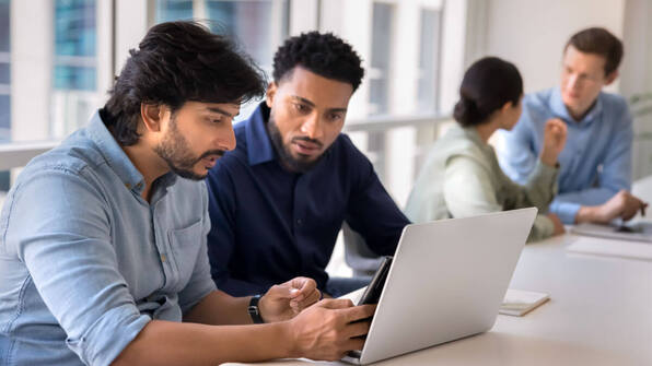 People sat in an office discussing how to implement Total Quality Management | Scilife