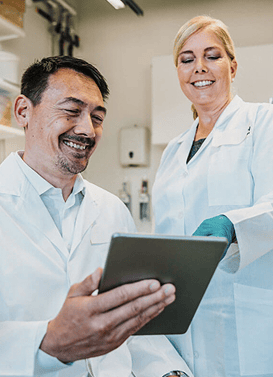 Two lab technicians reviewing information on a tablet | Scilife