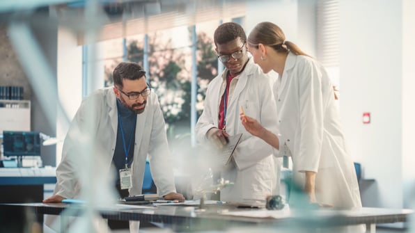 Image that represents a team discussing how to overcome the challenge of onboarding from a paper-based system to an eQMS | Scilife