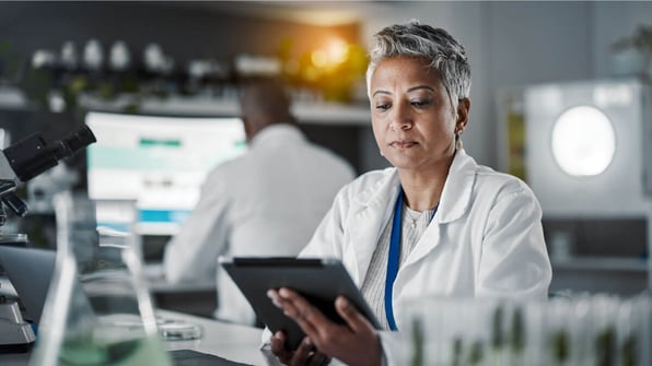Female scientist looking down at her tablet | Scilife