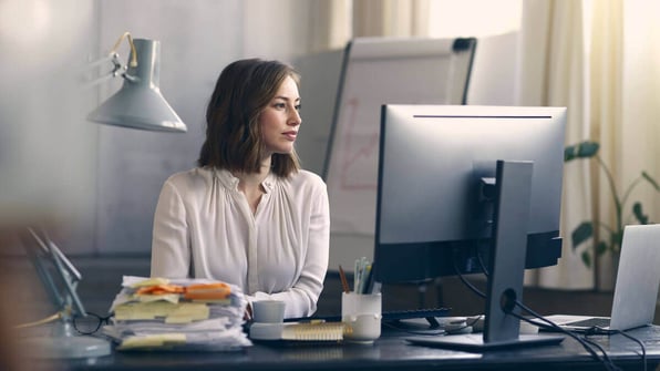 A woman working at a computer in an office setting | Scilife