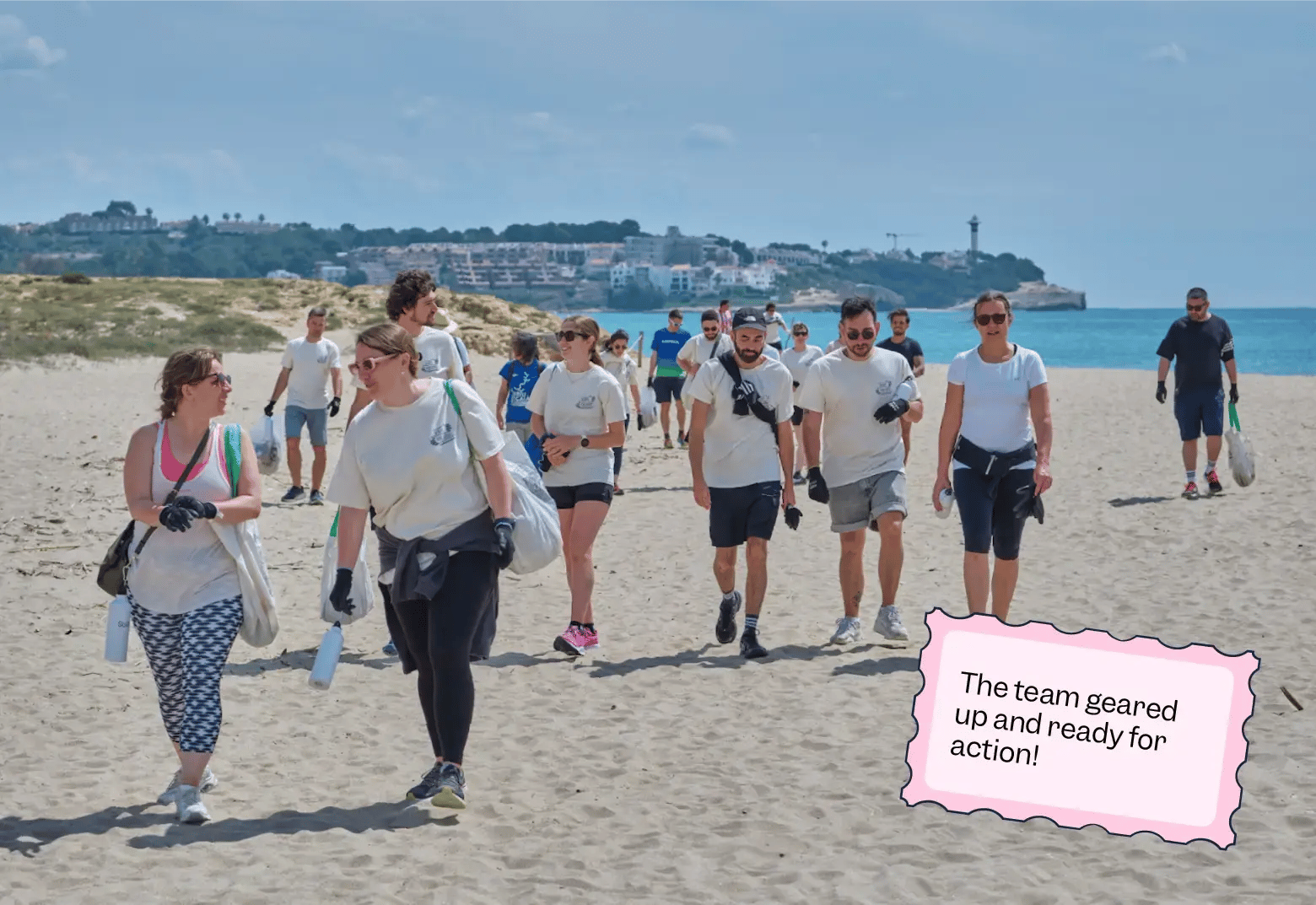 Photo of Scilife team members walking along the Altafulla beach, geared up with gloves and trash bags as part of their “Scilife for Good” cleanup day | Scilife