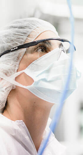 Researcher in a lab with face mask as representation of 3p biopharmaceuticals quote for the quality platform for pharma and biotech Scilife