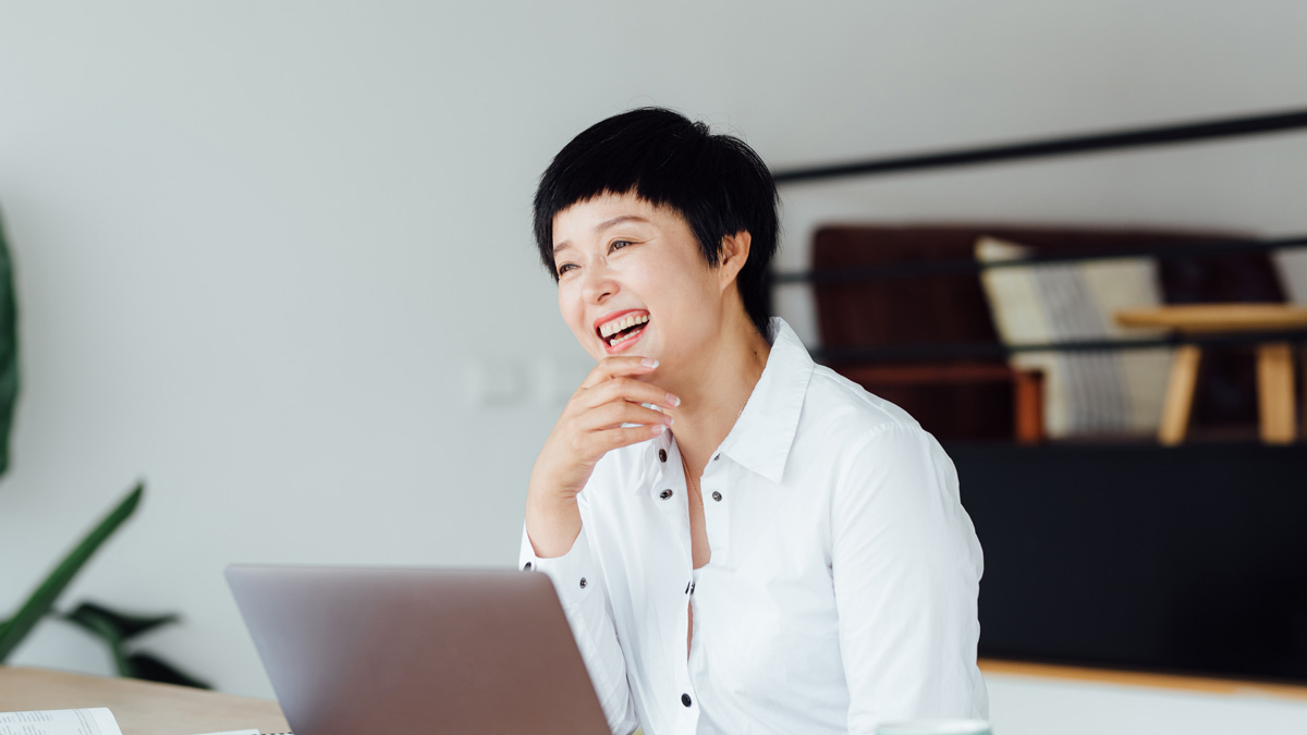 Woman smiling with a laptop to illustrate our Scilife Customer Stories