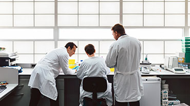 3 men with white clothes working on a lab to illustrate Scilife Software Platform for Enterprise